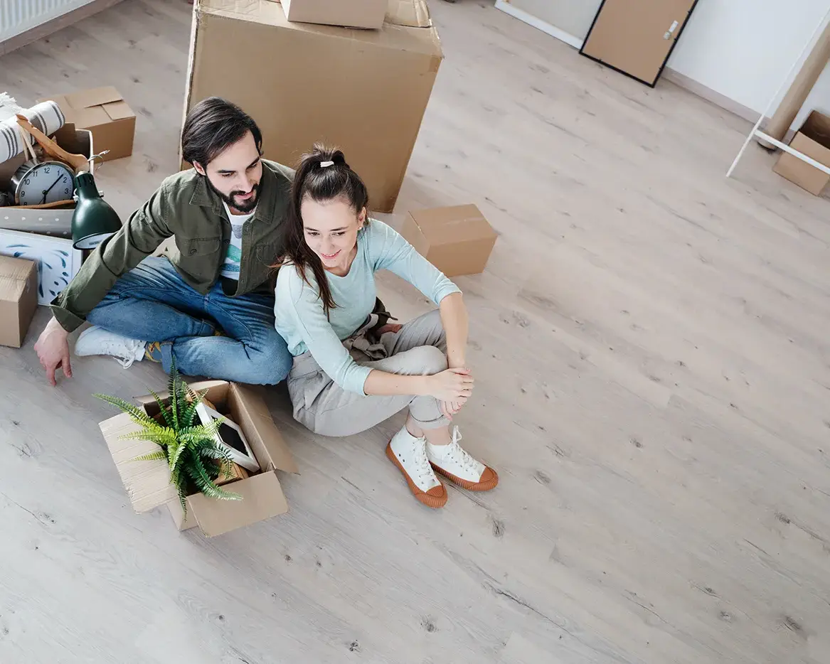 A photo of a first home buyer on the central coast sitting on the floor of their new home.