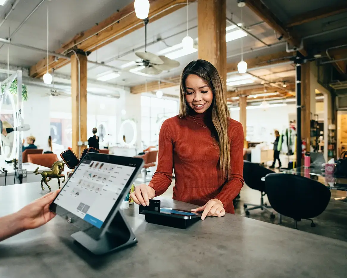 A photo of a lady purchasing an item from a business that secured a business loan from Maplefly Money