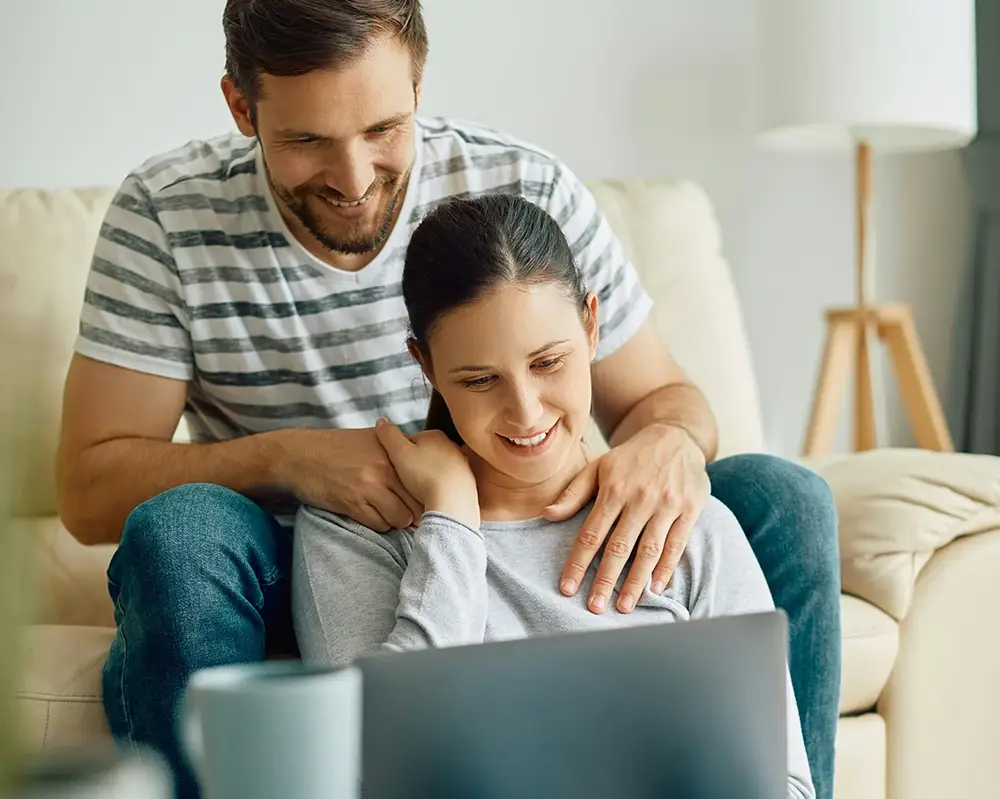 Couple looking at their computer using on of the mortgage calculators